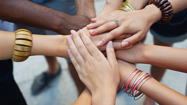 Un grupo de manos diversas unidas en una muestra de unidad y trabajo en equipo.