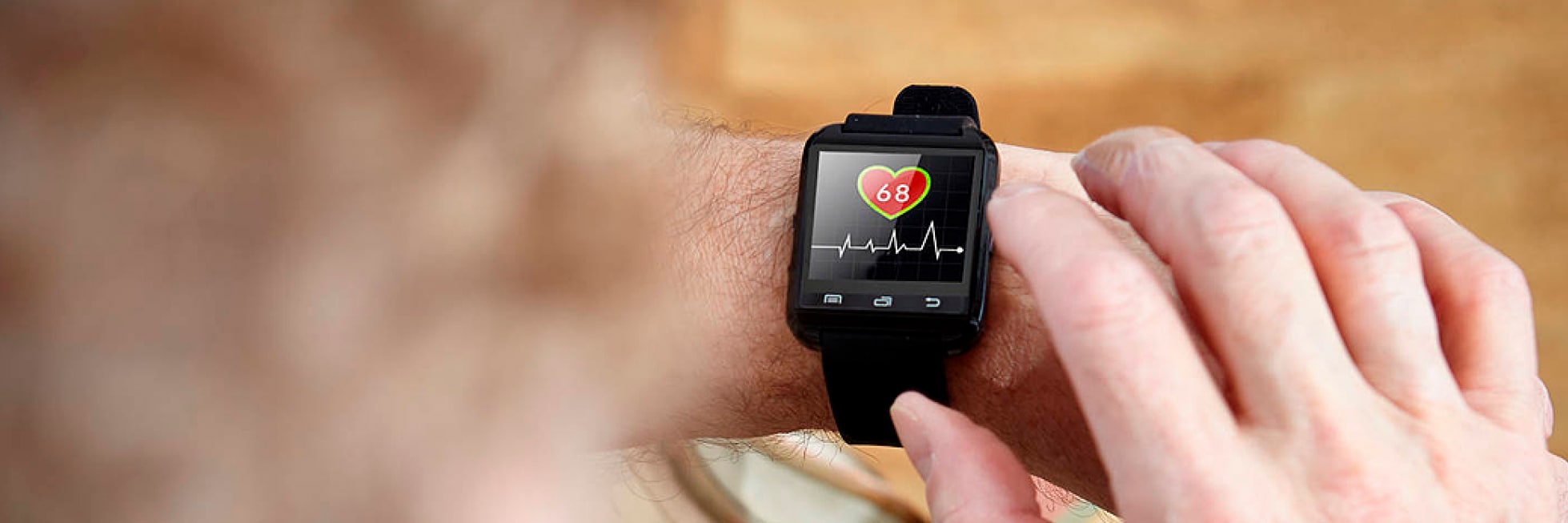 Una persona interactúa con un reloj inteligente que muestra una frecuencia cardíaca de 68 y un gráfico de ECG.